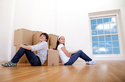 Removal team handling boxes and furniture in a Kensington apartment building